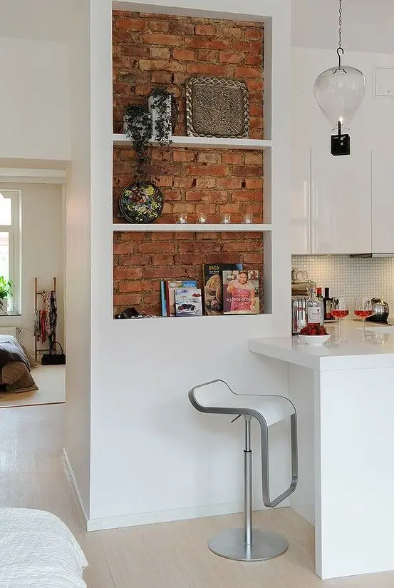 white kitchen with red brick wall