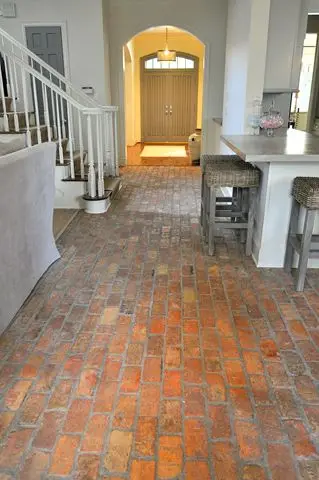 hallway with warm red brick floor