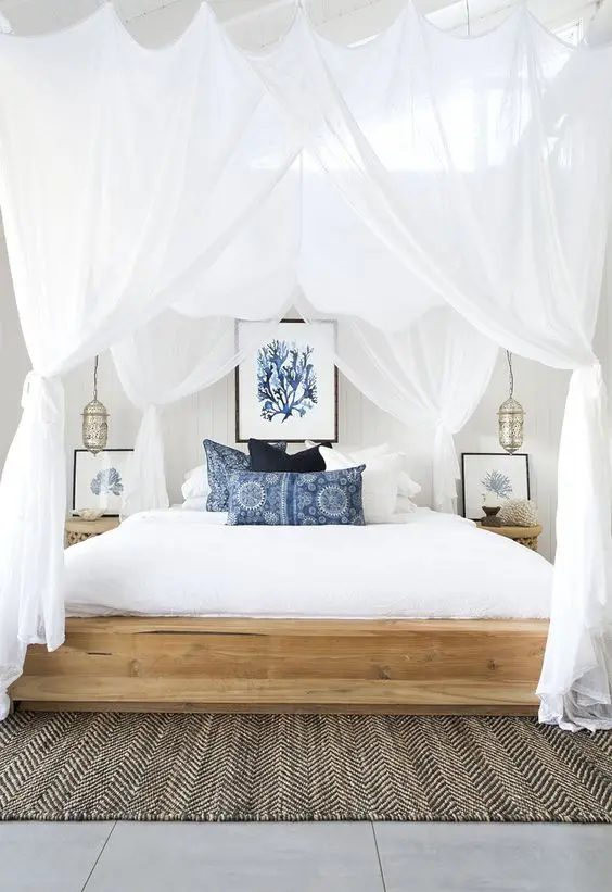 bed with white canopy curtains