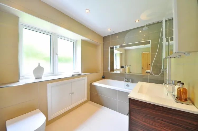 Bright modern bathroom with a bath, timber vanity and a window